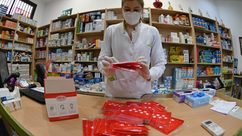 11/05/2020.- La trabajadora prepara las mascarillas que se repartirán gratuitamente entre los ciudadanos, este lunes, en una farmacia de Alcalá de Henares, Madrid. Los madrileños podrán recoger desde este lunes y durante 15 días una mascarilla FFP2 d