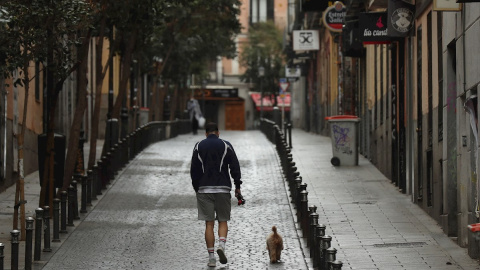 Un hombre pase a su perro en el madrileño barrio de Malasaña. EFE/Kiko Huesca