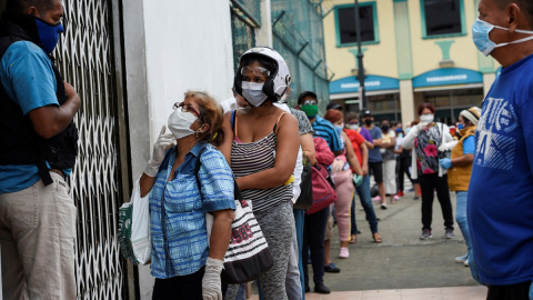 Varias personas hacen cola frente a una farmacia en Guayaquil, Ecuador. REUTERS