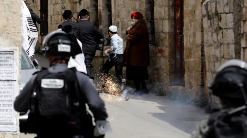 La Policía israelí lanza una granada aturdidora a varios judíos ultraortodoxos en las calles de Jerusalén./ Ronen Zvulun (Reuters)