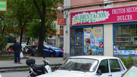 Dos vecinos del Barrio del Pilar conversan en la calle –pese a la prohición– frente a un local de alimentación regentado por una familia china. JOSE CARMONA.