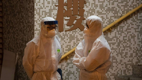 Dos personas, en un edificio de Hong Kong. (JEROME FAVRE | EFE)