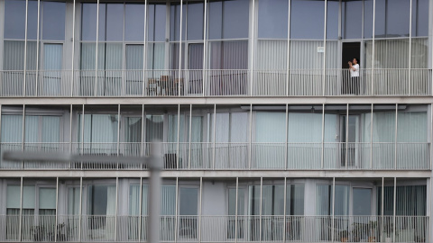 BILBAO, 15/05/2020.-Una mujer sale al balcón de su casa al tradicional aplauso a los sanitarios este viernes en Bilbao, dentro del estado de alarma sanitaria debido a la pandemia del coronavirus. EFE/LUIS TEJIDO.