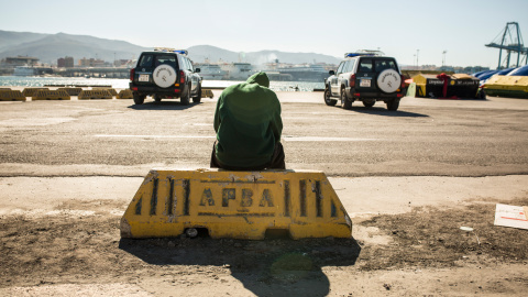 Un migrante descansa en el puerto de Algeciras, custodiado por la Guardia Civil tras ser rescatado por Salvamento Marítimo junto a potros migrantes a bordo de una patera.- JAIRO VARGAS