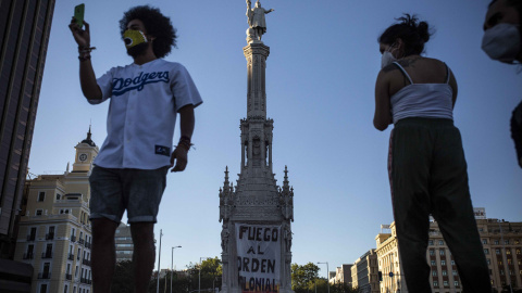 Dos activistas durante el asalto a la estatua de Colón en Madrid.- JAIRO VARGAS