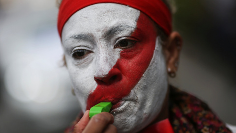 Una taxista de Madrid con el rostro pintado con los colores de los taxis de la capital, en una manifestación contra Uber en abril. REUTERS/Susana Vera