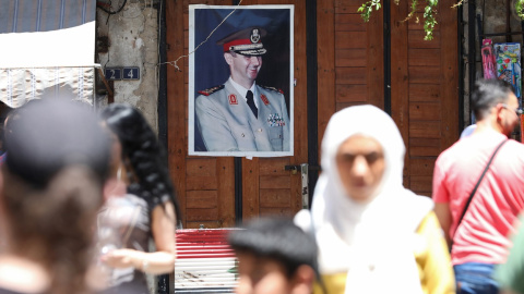 Varias personas pasan por una calle de Damasco, cerca de un retrato del presidente Sirio, Bashar al-Assad. AFP/LOUAI BESHARA