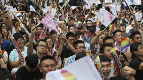 Dos integrantes de la comunidad LGBT se abrazan mientras celebran la decisión del Tribunal Constitucional sobre el matrimonio entre personas del mismo sexo ante el Parlamento en Taipei / EFE