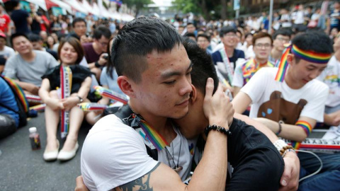 Dos integrantes de la comunidad LGBT (lesbianas, gais, bisexuales y transexuales) se abrazan mientras celebran la decisión del Tribunal Constitucional sobre el matrimonio entre personas del mismo sexo ante el Parlamento en Taipei / EFE