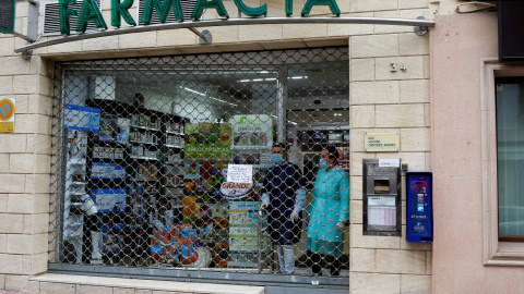 Empleados de una farmacia cerrada durante el estado de alarma por la pandemia del coronavirus.. REUTERS/Jon Nazca