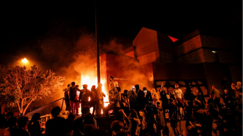 Los manifestantes se reúnen tras prender fuego a la entrada de una estación de policía mientras continúan las manifestaciones por George Floyd. REUTERS / Carlos Barria