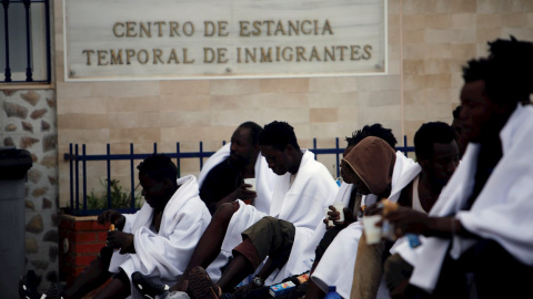 Varios inmigrantes desayunan mientras son atendidos por los servicios sanitarios tras conseguir saltar la valla, que separa la ciudad autónoma de Melilla de Marruecos, este lunes. EFE/F.G. Guerrero