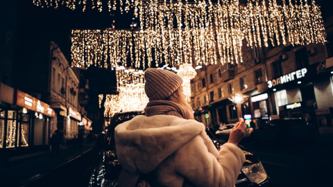 Una mujer observa las luces navideñas que iluminan las calles.- Pixabay