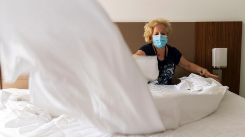 Una trabajadora de un hotel prepara las habitaciones para recibir a los turistas tras el estado de alarma. EFE/ CATI CLADERA