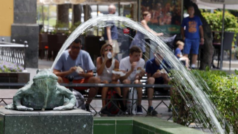 Unos turistas descansan en la plaza de Las Ranas, en Las Palmas, durante la reciente ola de calor registrada en Canarias. EFE/Elvira Urquijo A.