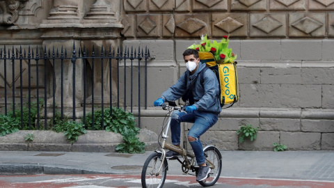 Un ryder de Glovo circula amb la motxilla plena de roses. ACN