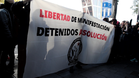 Jóvenes integrantes del Movimiento Antirrepresivo de Madrid con una pancarta en la que se lee, `Libertad de Manifestación, Detenidos Absolución´, concentrados frente a los juzgados de Plaza de Castilla en apoyo a los detenidos en el centro de Madrid d