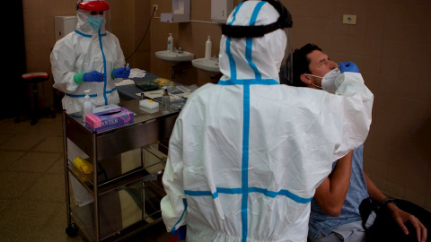 Una profesional sanitaria realiza una prueba PCR a un paciente. EFE/Enric Fontcuberta/Archivo