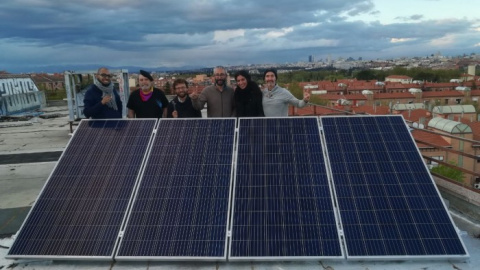 Activistas del EKO de Carabanchel junto a una placa fotovoltaica en su azotea.