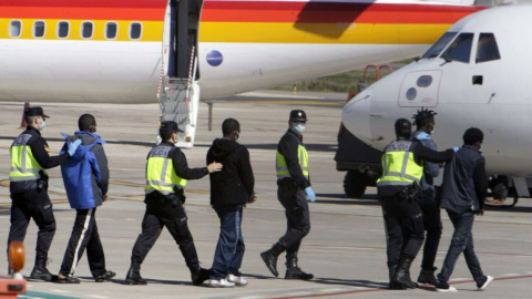 La Policía traslada hasta el avión a un grupo de inmigrantes que va a deportar desde Melilla.- EFE / ARCHIVO