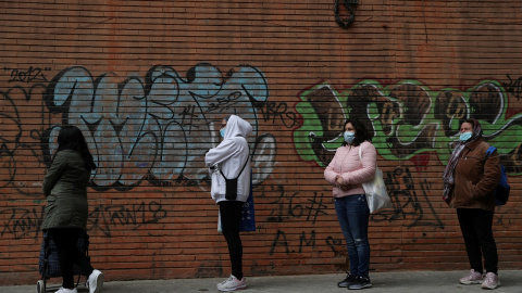 Personas  haciendo cola para recibir alimentos donados por voluntarios de la asociación Vecinos Parque Aluche, en Madrid, durante el estado de alarma por la pandemia del coronavirus. REUTERS / Susana Vera