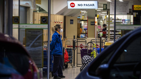 Una trabajadora de un supermercado vigila el aforo limitado durante el estado de alarma por la emergencia del coronavirus. / JAIRO VARGAS