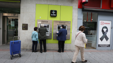 Personas mayores sacan dinero en un cajero de Bankia durante el estado de alarma por la crisis del coronavirus. E.P./Marta Fernández