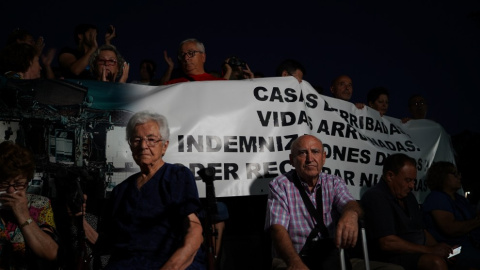 Un grupo de vecinos afectados por la línea 7B de Metro de Madrid esperan en la calle con sus maletas y una pancarta. -Iván Fuentes / Cedida