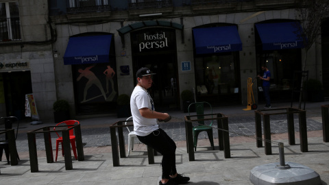 Un trabajador arrastra el soporte de una sombrilla para una terraza de una cafetería en el centro de Madrid. REUTERS/Susana Vera