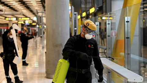 Efectivos de la UME durante las labores de desinfección, este jueves, en la T-4 del Aeropuerto de Madrid-Barajas durante la cuarta jornada laboral de aislamiento para frenar el avance del coronavirus. EFE/Fernando Villar