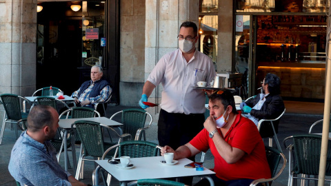 Un camarero sirve a los clientes en su bar de la Plaza Mayor de Salamanca. EFE/JM García