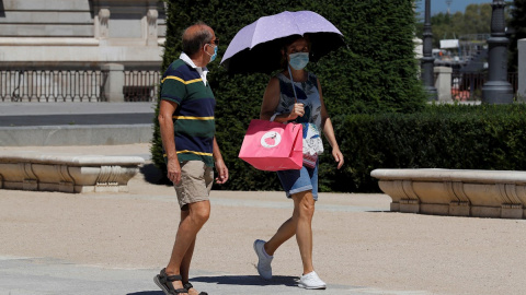 Dos personas pasean por el centro de Madrid, este lunes. | EFE