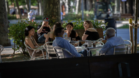 Varias personas disfrutan en la terraza de un bar de Barcelona.