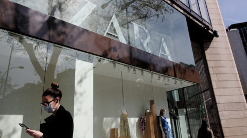 Una mujer con mascarilla pasa junto al escaparate de la tienda Zara, la principal enseña de Inditex, en Madrid. E.P./Eduardo Parra