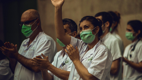 El personal sanitari de l’Hospital Clínic aplaudeix, després de la crida a través de les xarxes per a una darrera ronda d’aplaudiments en homenatge a professionals sanitaris i altres sectors, que lluiten contra la pandèmia del coronavirus.  Matthi