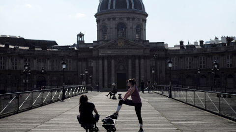 19/03/2020.- Mujeres hacen ejercicio en el Puente de las Artes de París (Francia) pese a las limitaciones de libertad de movimiento por el coronavirus. / EFE - JULIEN DE ROSA