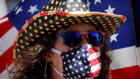 Un manifestante con una máscarilla con los colores de la bandera de EEUU en una protesta contra el cierre de actividad y de negocios decretado por la pandemia del coronavirus, en Los Ángeles (California, EEUU). REUTERS / Mike Blake