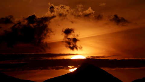 El sol se esconde entre las montañas en una jornada donde el cielo despejado y el calor han sido las notas características de este día en la capital navarra EFE/ Jesús Diges