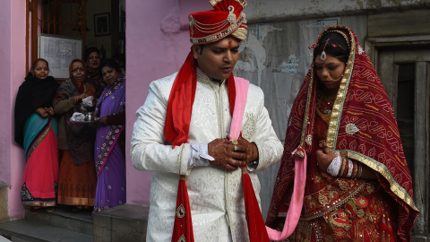 Una pareja de recién casados son observados por varios familiares tras visitar un templo en Nueva Delhi. AFP/ Prakash Singh