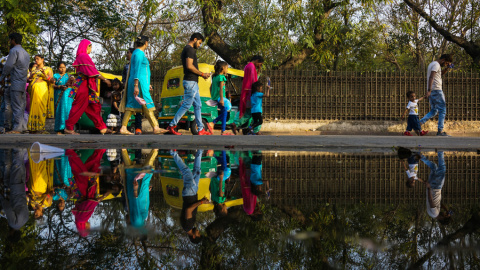 Varios habitantes de Nueva Delhi caminan por una calle encharcada. AFP/Chandan Khanna