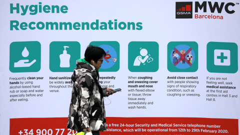 Una persona pasa junto a un cartal on información de seguridad para el Mobile World Congress (MWC20 ) en Barcelona. REUTERS/Nacho Doce