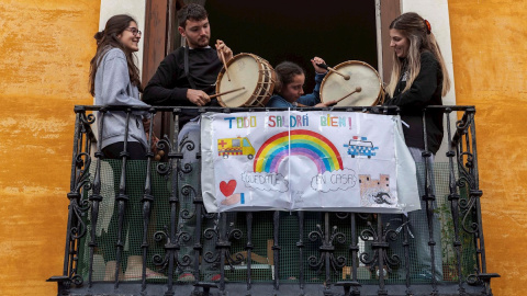 Varios miembros de una familia tocan el tambor desde el balcón de su vivienda de la ciudad murciana de Mula, que ha adelantado a las 20 horas la tradicional rompida de la hora de la medianoche del Martes Santo. EFE/Marcial Guillén