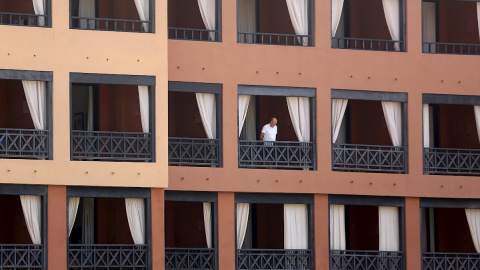 Un turista se asoma desde el balcón de su habitación en el hotel del sur de Tenerife. - EFE