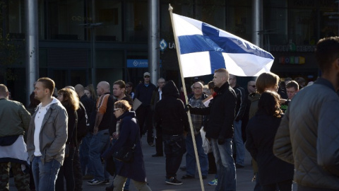 Un manifestante antiinmigración con una bandera de Finlandia durante una protesta en Helsinki. - AFP