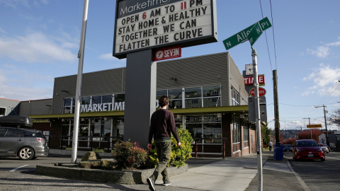 El letrero de un centro comercial pide "quédese en casa y cuidese; juntos podemos aplanar la curva", en la ciudad de Seattle (Washington, EEUU). REUTERS / Jason Redmond