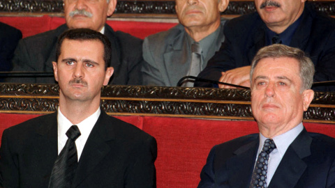 El presidente sirio Bashar al-Assad (izq.) y el ex vicepresidente Abdul-Halim Khaddam participan en una sesión del parlamento. Foto de archivo. Reuters