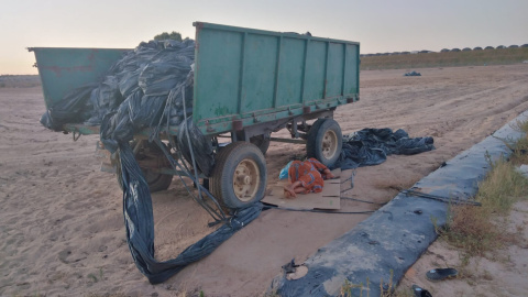 Una temporera duerme la siesta a la sombra de un remolque debido al calor que hace en los barracones donde se alojan.- MUJERES 24 HORAS