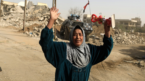 Una mujer levanta los brazos en medio de la batalla en Mosul (Irak). /REUTERS