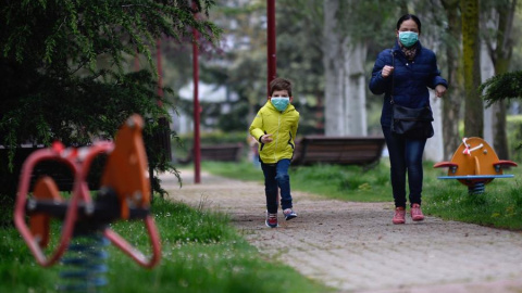 Un niño protegido con una mascarilla corre esta mañana por un parque de la ciudad de Valladolid durante el primer día en el que los menores de 14 años salen a la calle, acompañados de un adulto y durante una hora, después de más de cuarenta días d