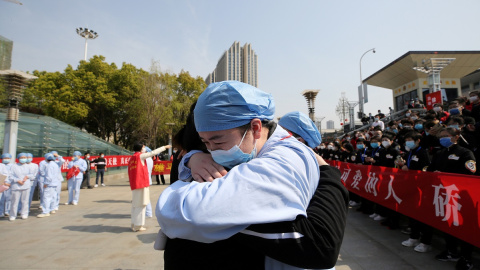 Dos enfermeros chinos se abrazan. REUTERS